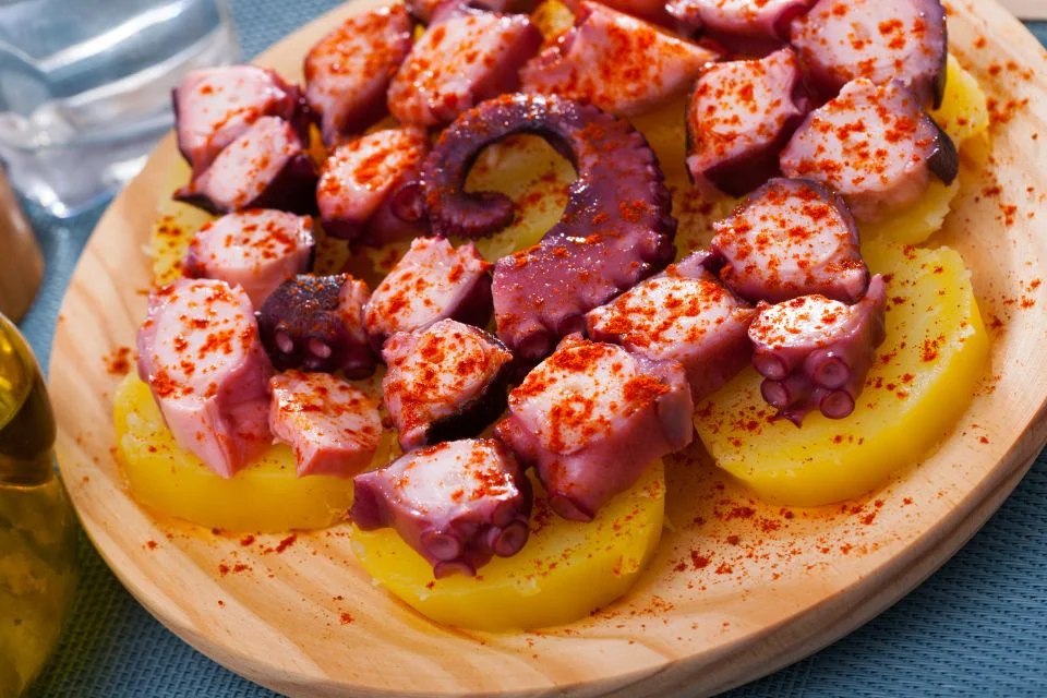 boiling octopus marinated in paprika, salt, and olive oil