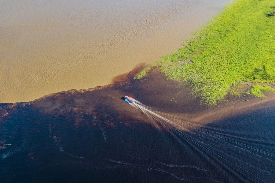 The Meeting of Waters is the confluence between the dark Rio Negro and the pale sandy-colored Amazon River